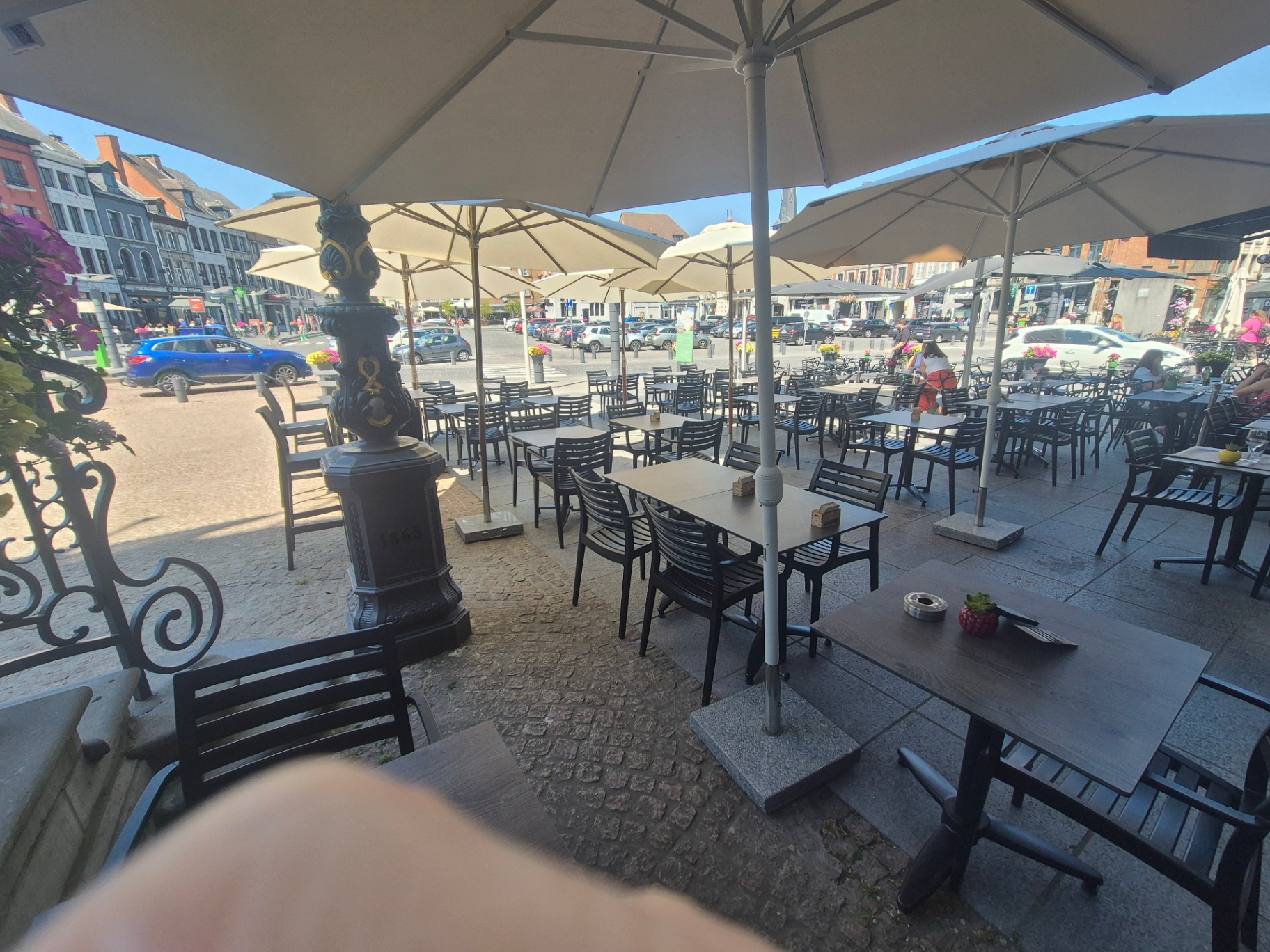 Vue panoramique de la Grand-Place depuis la terrasse abritée sous les parasols