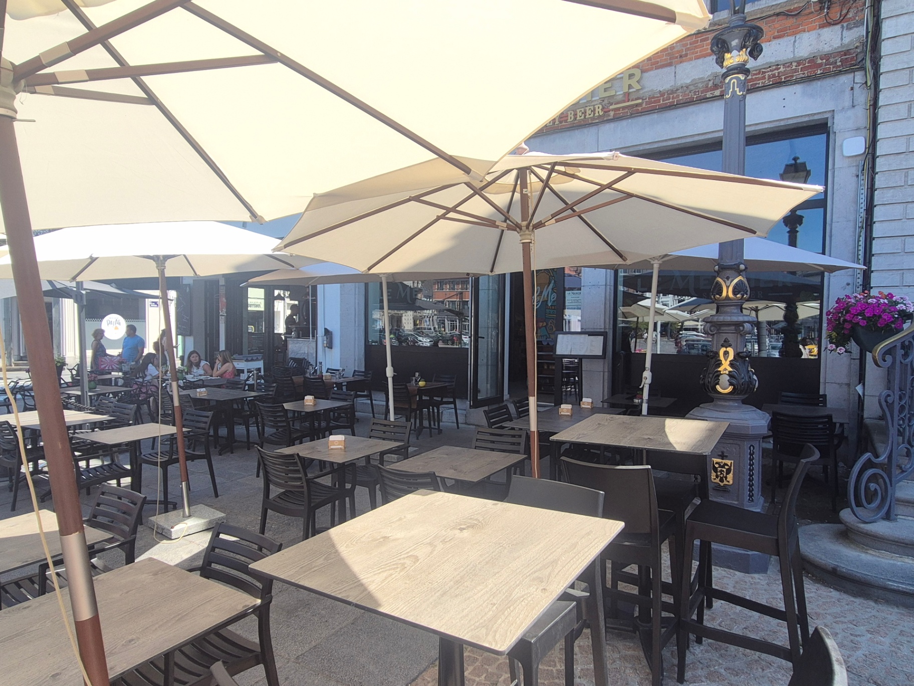 Parasols crème et tables en bois de la terrasse au soleil